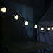 String lights hanging above a table with a dark background